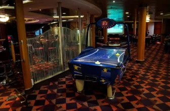 Air hockey table on board at P&O Ferries with the upper level of the Show Bar in the background and a video screen showing a football match.