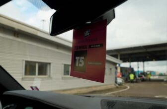 Cardboard hanger on the rear-view mirror displaying ferry information.