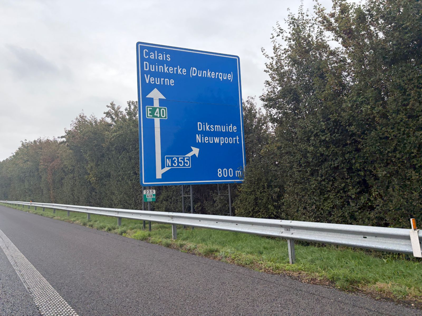 Blue motorway sign on the E40 in Belgium pointing to Calais, Duinkerke (Dunkerque) and Veurne
