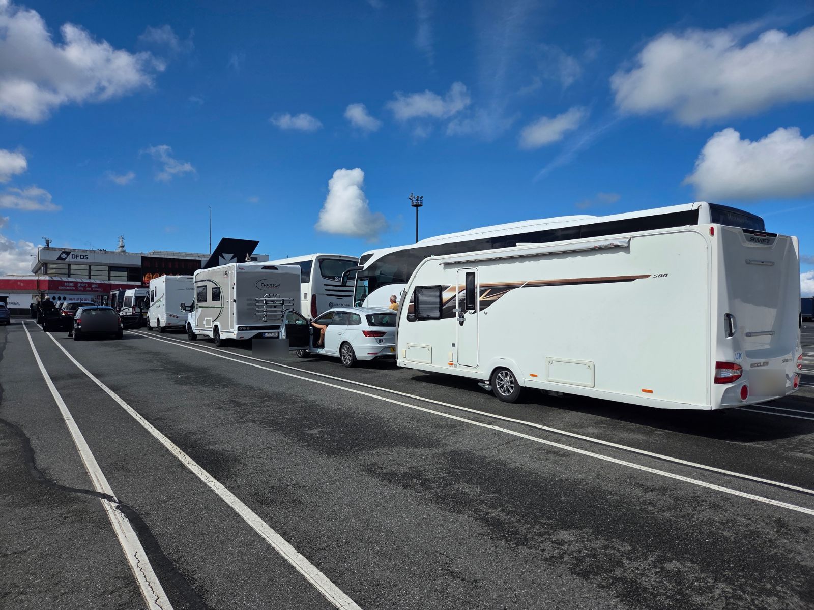 Coaches, motorhomes, cars and a caravan lined up in the DFDS boarding lanes at Dunkirk