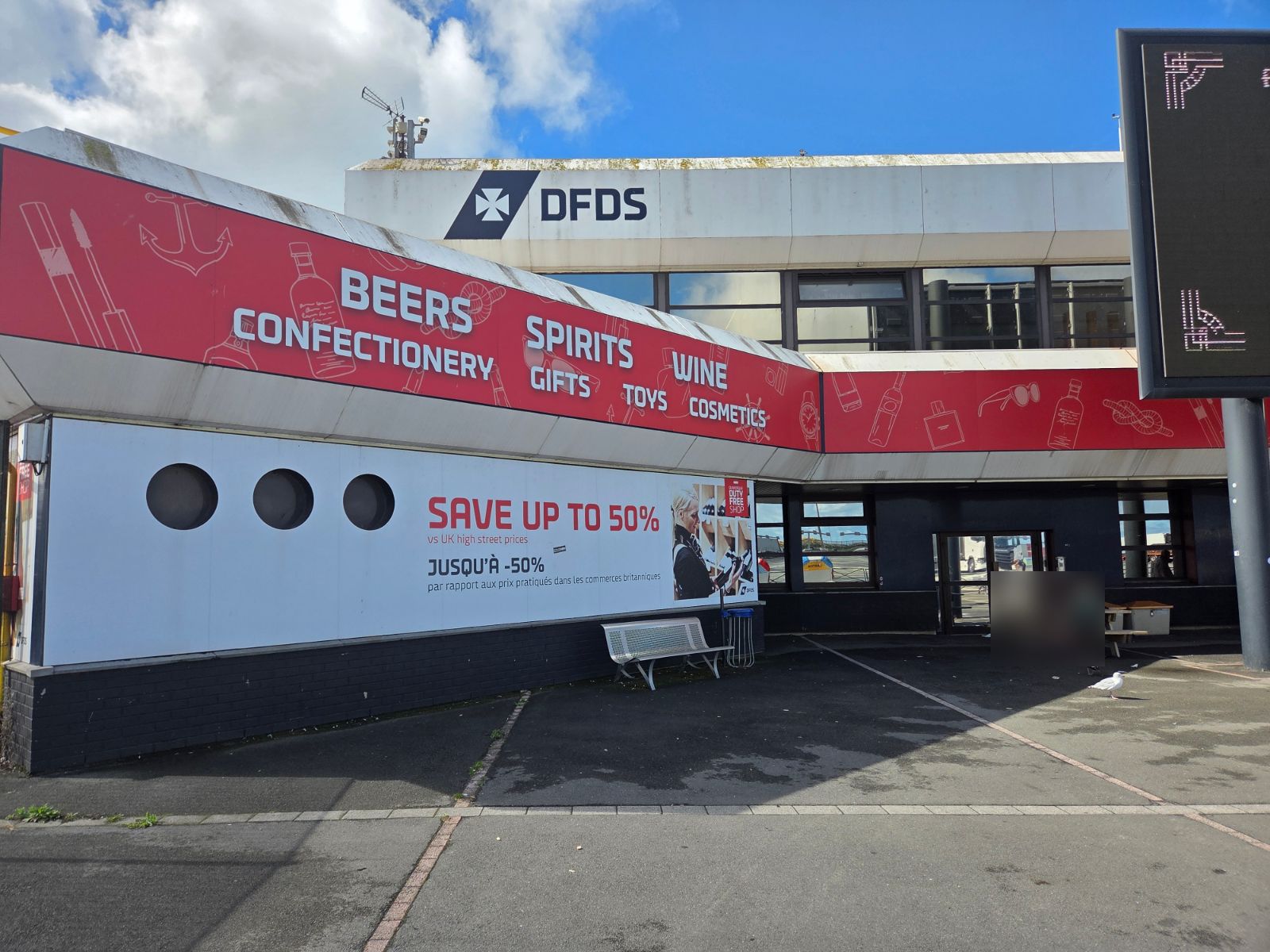 DFDS terminal building at Dunkirk with a red duty free banner and picnic tables outside