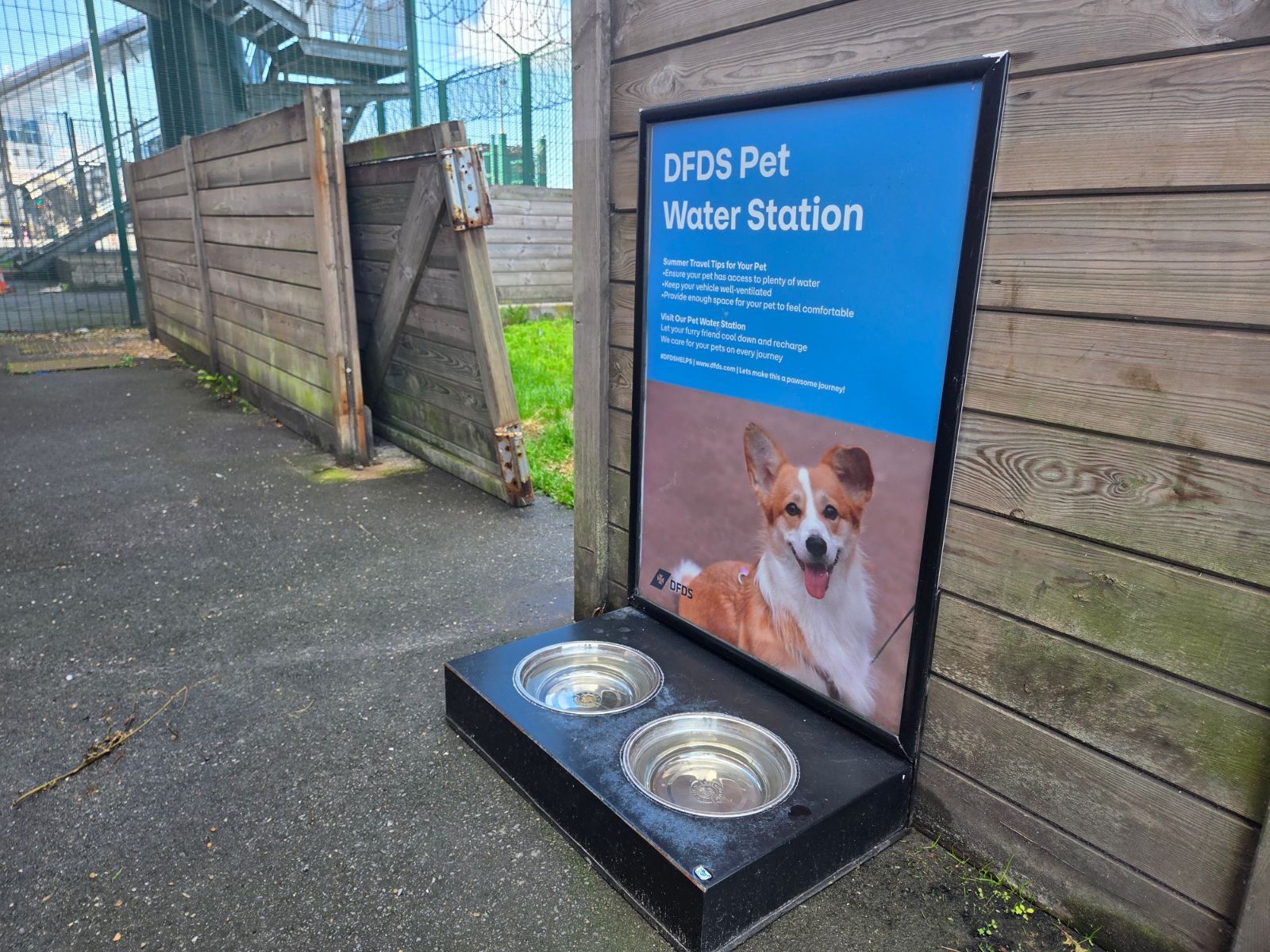 DFDS pet water station with two metal bowls next to a wooden fence at the Dunkirk terminal