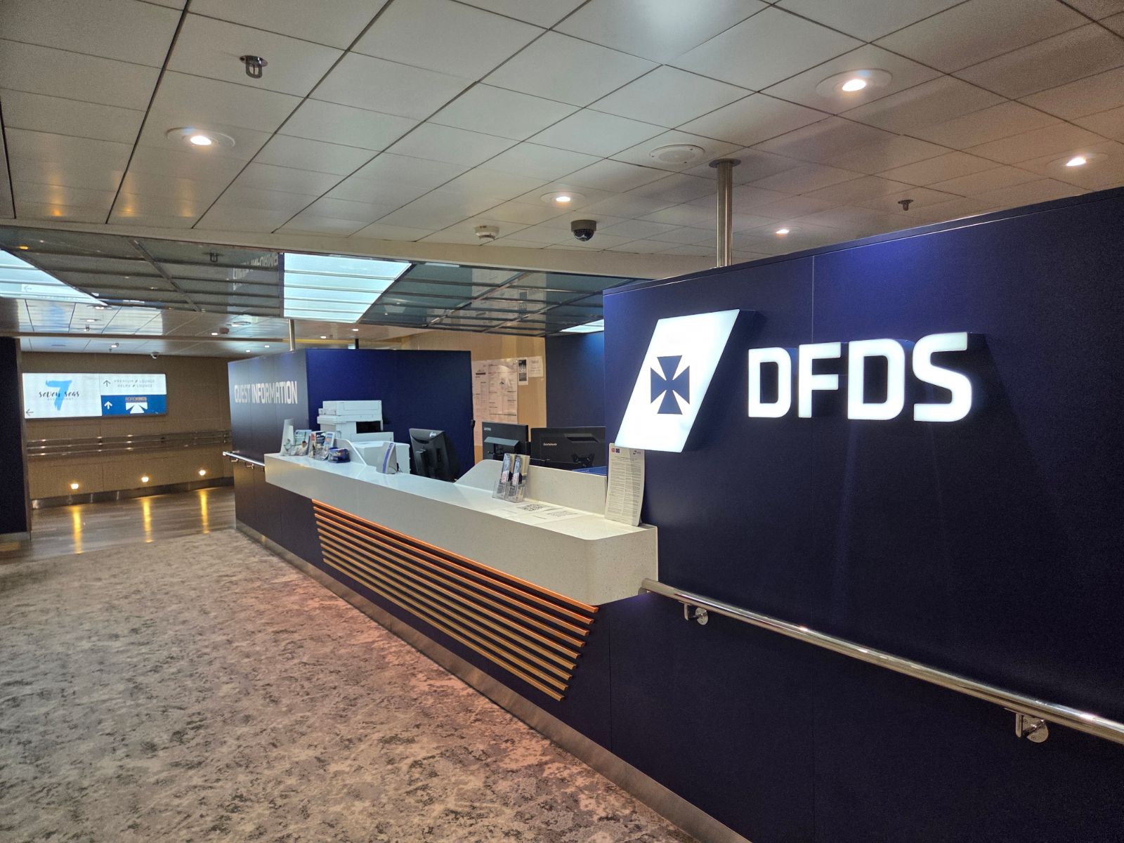 DFDS guest information desk on Delft Seaways with signs to the Seven Seas restaurant and lounges